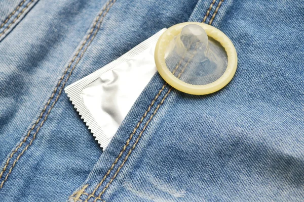 Condoom in de blauwe jeans zak — Stockfoto