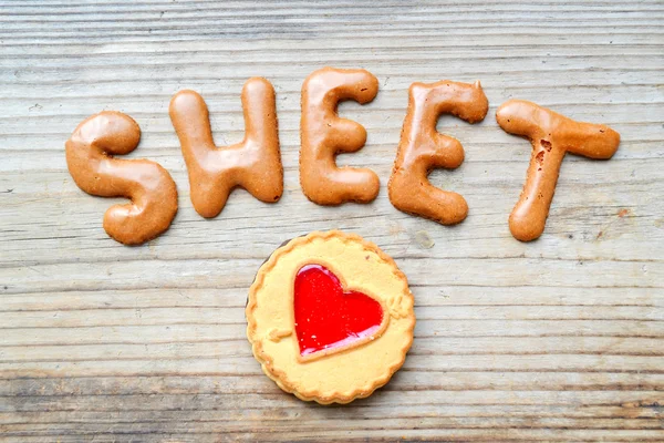 Λέξης γλύκισμα με μπισκότα σοκολάτας αλφάβητο στο ξύλινο τραπέζι — Φωτογραφία Αρχείου