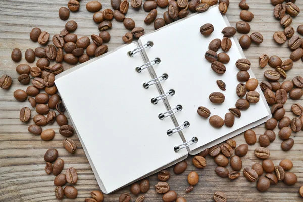 有很多烘培咖啡豆的空复古螺旋笔记本 — 图库照片
