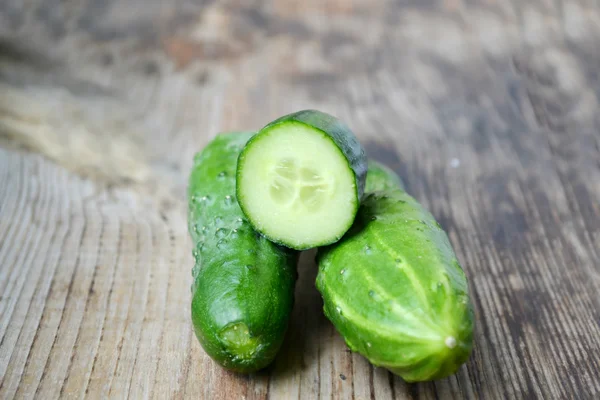 Verse groene komkommers op woodem tafel — Stockfoto