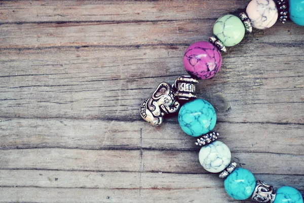 Childish and girly bracelet with blue gems and elephant pendants in Shamballa style on wooden table — Stock Photo, Image