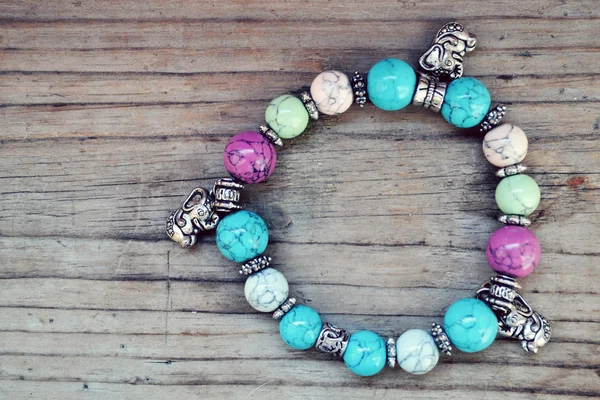 Childish and girly bracelet with blue gems and elephant pendants in Shamballa style on wooden table — Stock Photo, Image