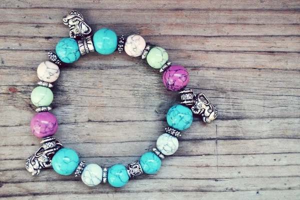 Childish and girly bracelet with blue gems and elephant pendants in Shamballa style on wooden table — Stock Photo, Image