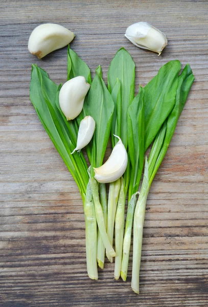 Lauch mit Knoblauchzehen auf Holztisch — Stockfoto