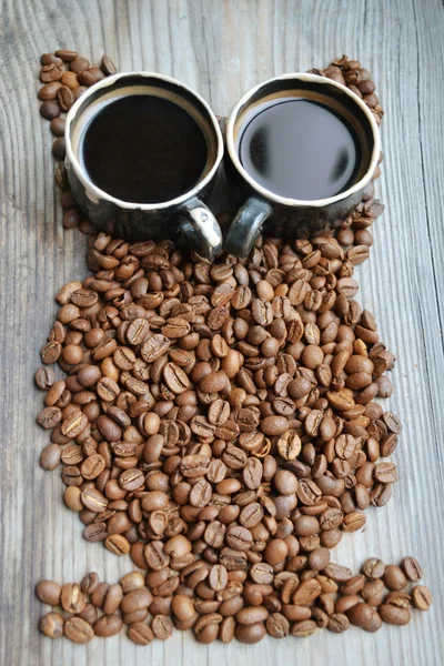 Un montón de granos de café tostados y tazas de café en forma de búho — Foto de Stock