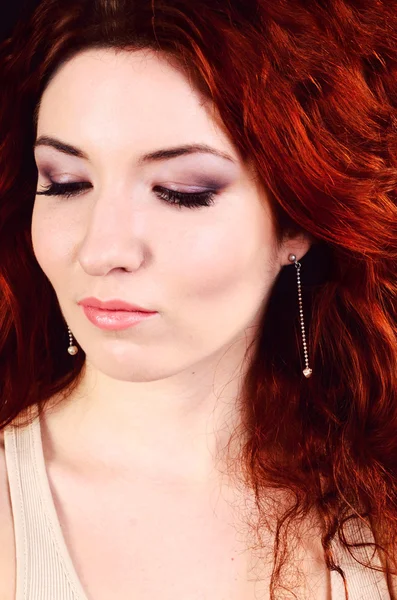 Beautiful young redhead woman with perfect daytime makeup and long silver earrings smiling playfully — Stock Photo, Image