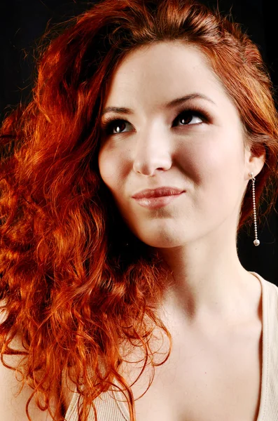 Beautiful young redhead woman with perfect daytime makeup and long silver earrings smiling playfully — Stock Photo, Image