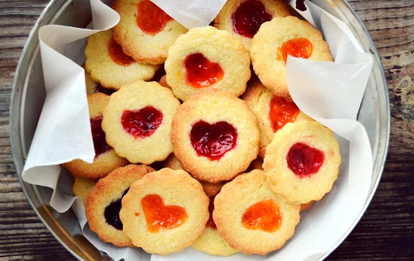 Galletas caseras con mermelada en forma de corazón en mesa de madera — Foto de Stock