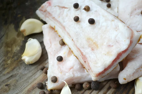 Lemak babi putih disebut salo dengan bawang putih dan lada di meja dapur kayu — Stok Foto