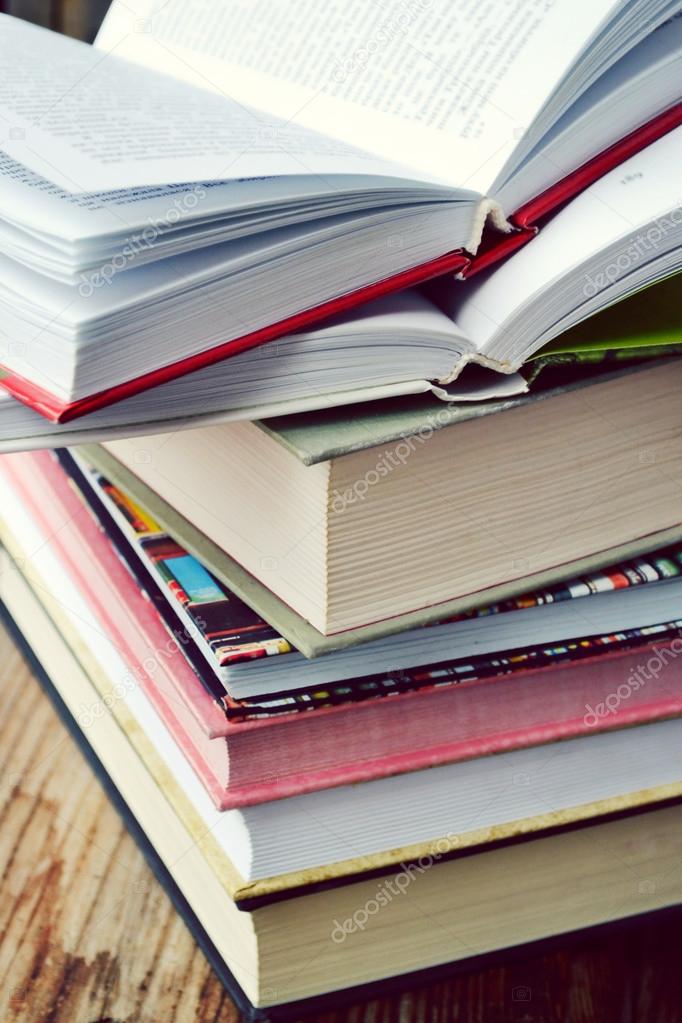 Pile of books on wooden desk