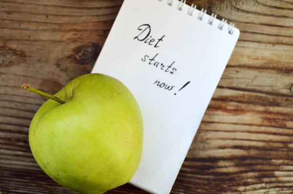 Ernährungskonzept mit grünem Apfel, Notizbuch und Maßband auf Holztisch — Stockfoto