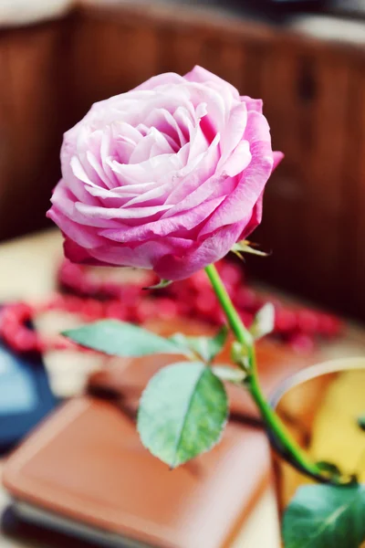 Rosa rosa en un pequeño jarrón sobre una mesa de madera —  Fotos de Stock