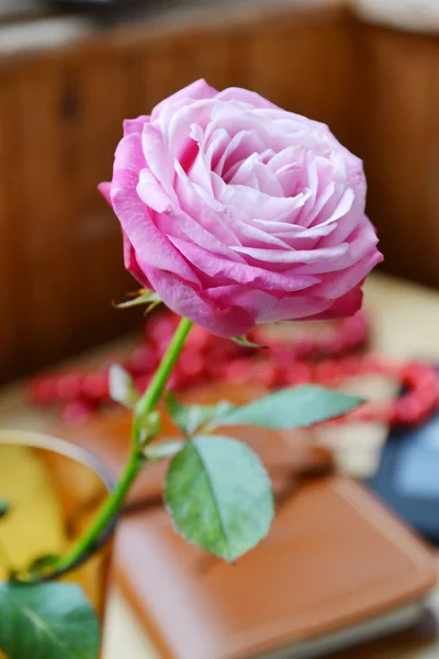 Rosa rosa en un pequeño jarrón sobre una mesa de madera —  Fotos de Stock