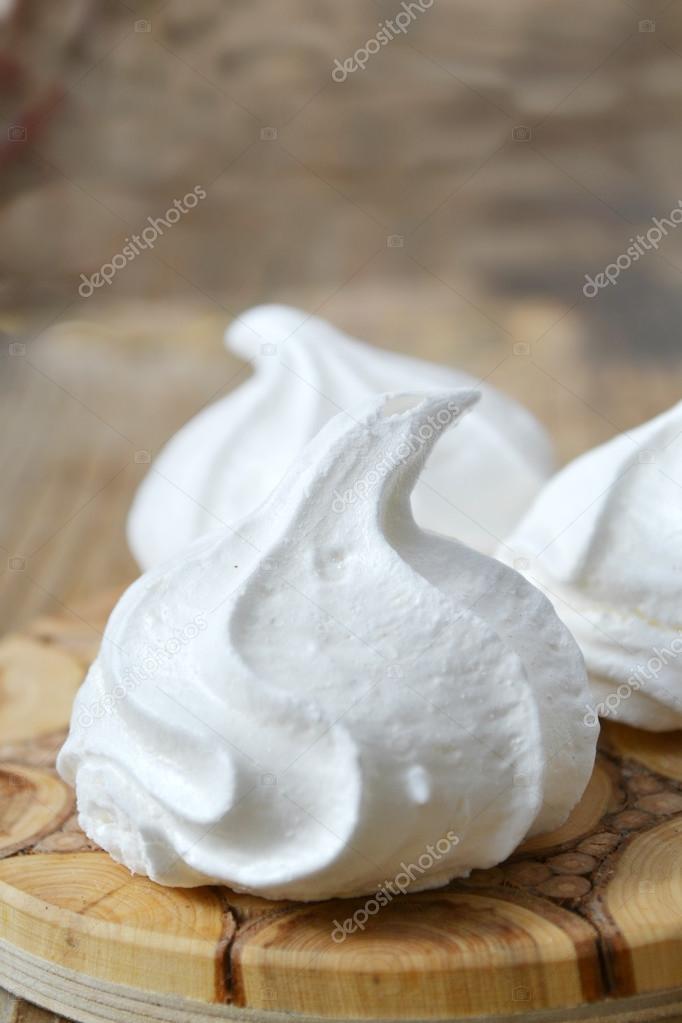 Three white bizet cookies on wooden table