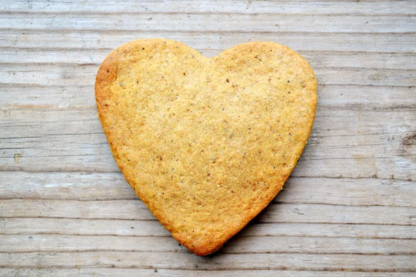 Gingerbread cookies in shape of heart on wooden table — Stock Photo, Image