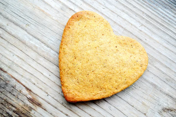 Gingerbread cookies in shape of heart on wooden table — Stock Photo, Image