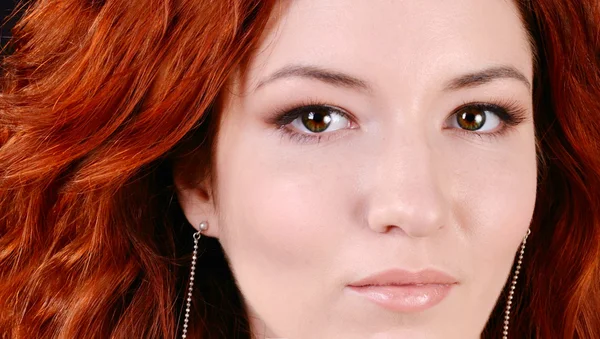 Beautiful young redhead woman with perfect daytime makeup and long silver earrings smiling playfully — Stock Photo, Image