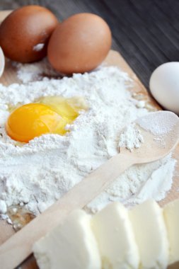 yumurta, tereyağı ve tahta kaşık yemek kartı üzerindeki beyaz un