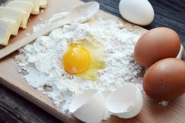 yumurta, tereyağı ve tahta kaşık yemek kartı üzerindeki beyaz un