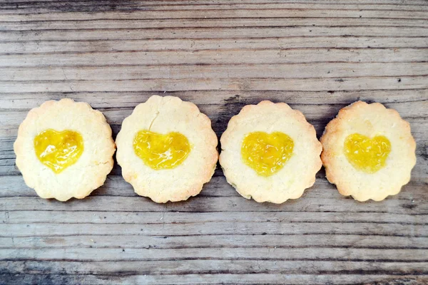 Galletas caseras con mermelada en forma de corazón en mesa de madera — Foto de Stock