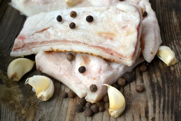 Witte varkensvlees reuzel genaamd salo met knoflook en peper op houten keukentafel — Stockfoto