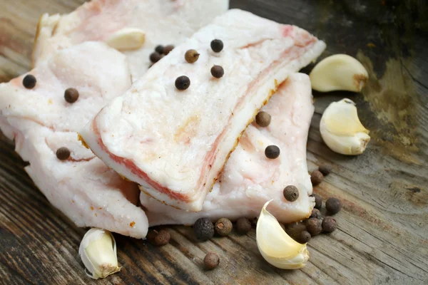 Witte varkensvlees reuzel genaamd salo met knoflook en peper op houten keukentafel — Stockfoto