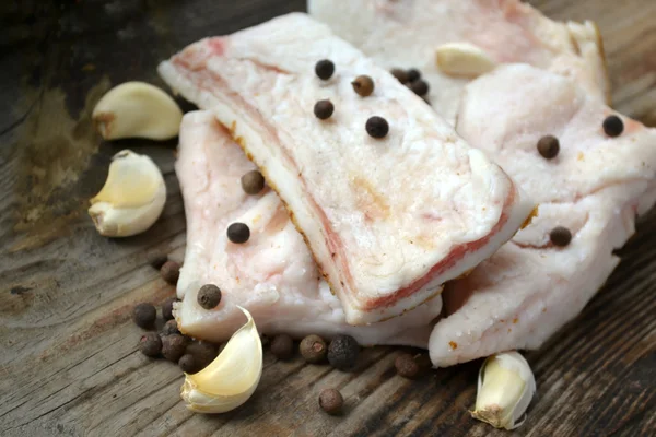 White pork lard called salo with garlic and pepper on wooden kitchen table — Stock Image White pork lard called salo with garlic and pepper on wooden kitchen table Stock Picture