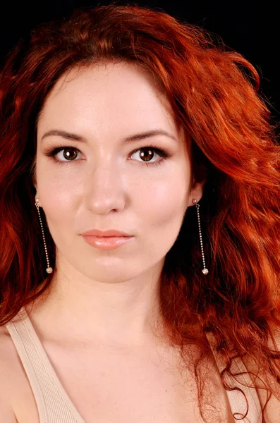 Beautiful young redhead woman with perfect daytime makeup and long silver earrings smiling playfully — Stock Photo, Image