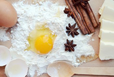 beyaz un yumurta, tereyağı, tarçın ile sopa, baharatlı anason yıldız ve tahta kaşık yemek oyun tahtası