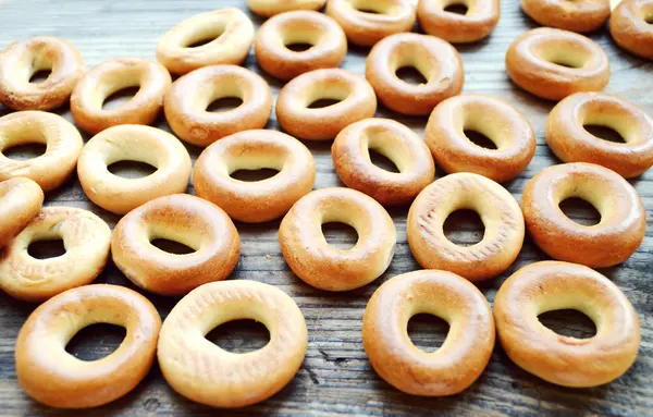 Beaucoup de petits bagels secs sur une table en bois — Photo