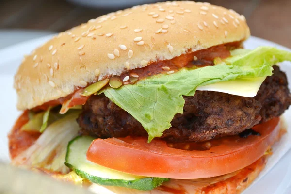 Hambúrguer saboroso com carne, salada e tomate — Fotografia de Stock