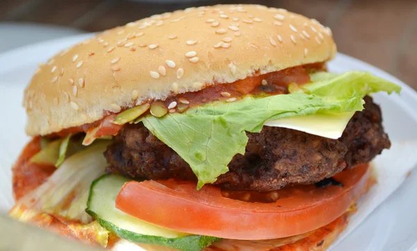 Leckere Burger mit Fleisch, Salat und Tomaten — Stockfoto