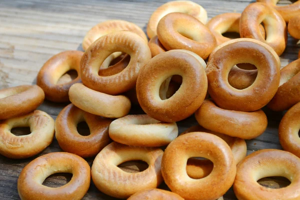 Montones de pequeños bagels secos en la mesa de madera —  Fotos de Stock