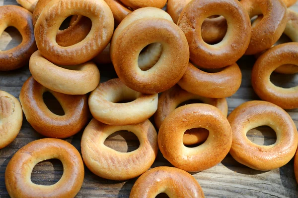 Montones de pequeños bagels secos en la mesa de madera —  Fotos de Stock