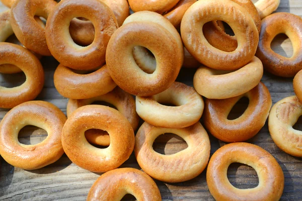 Lots of small dry bagels on wooden table — Stock Photo, Image