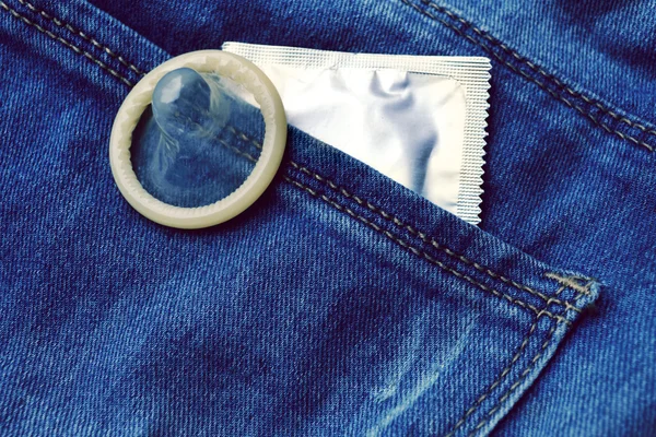 Preservativo nella tasca dei jeans blu — Foto Stock