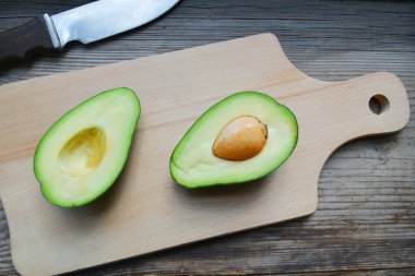 Ahşap masa üzerinde sağlıklı yeşil avokado