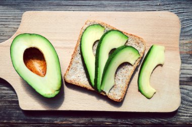 Ahşap masa üzerinde yeşil avokado ile sağlıklı sandviç