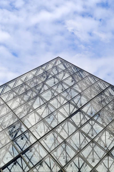 Paris, Fransa - 25 Mayıs, 2015: Ünlü Louvre Müzesi piramit yapılmış bardak mavi gökyüzü ve bulutlar yansımaları ile