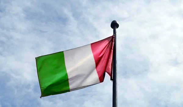 Nationella flagga Italien vajande över ljus blå himmel — Stockfoto