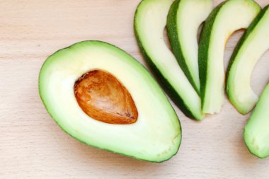 Ahşap masa üzerinde sağlıklı yeşil avokado