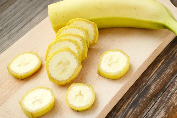 Gelbe Bananenscheiben auf Holzbrett — Stockfoto