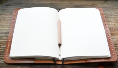 Bir boş retro notebook eski kağıt ile küçük kalem ve deri kapak