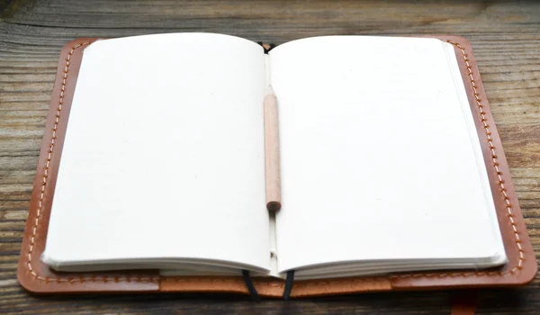 Bir boş retro notebook eski kağıt ile küçük kalem ve deri kapak