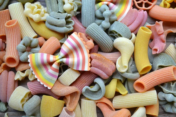 Conjunto de diferentes tipos de massas italianas coloridas na mesa de madeira — Fotografia de Stock