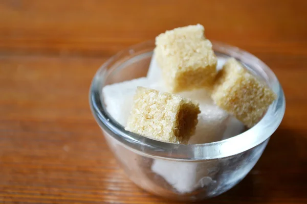 White and brown sugar cubes in a small bowl on wooden table — Stock Photo, Image