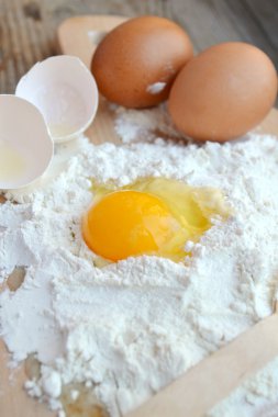 yumurta, tereyağı ve tahta kaşık yemek kartı üzerindeki beyaz un