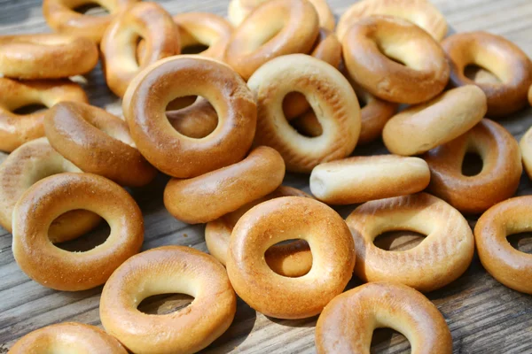 Lots of small dry bagels on wooden table — Stock Photo, Image