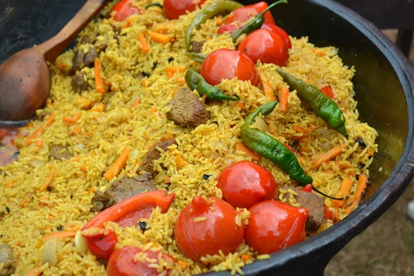 Olla grande con pilaf uzbeko con tomates y chiles verdes —  Fotos de Stock