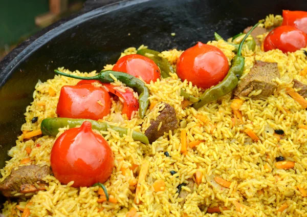 Olla grande con pilaf uzbeko con tomates y chiles verdes —  Fotos de Stock